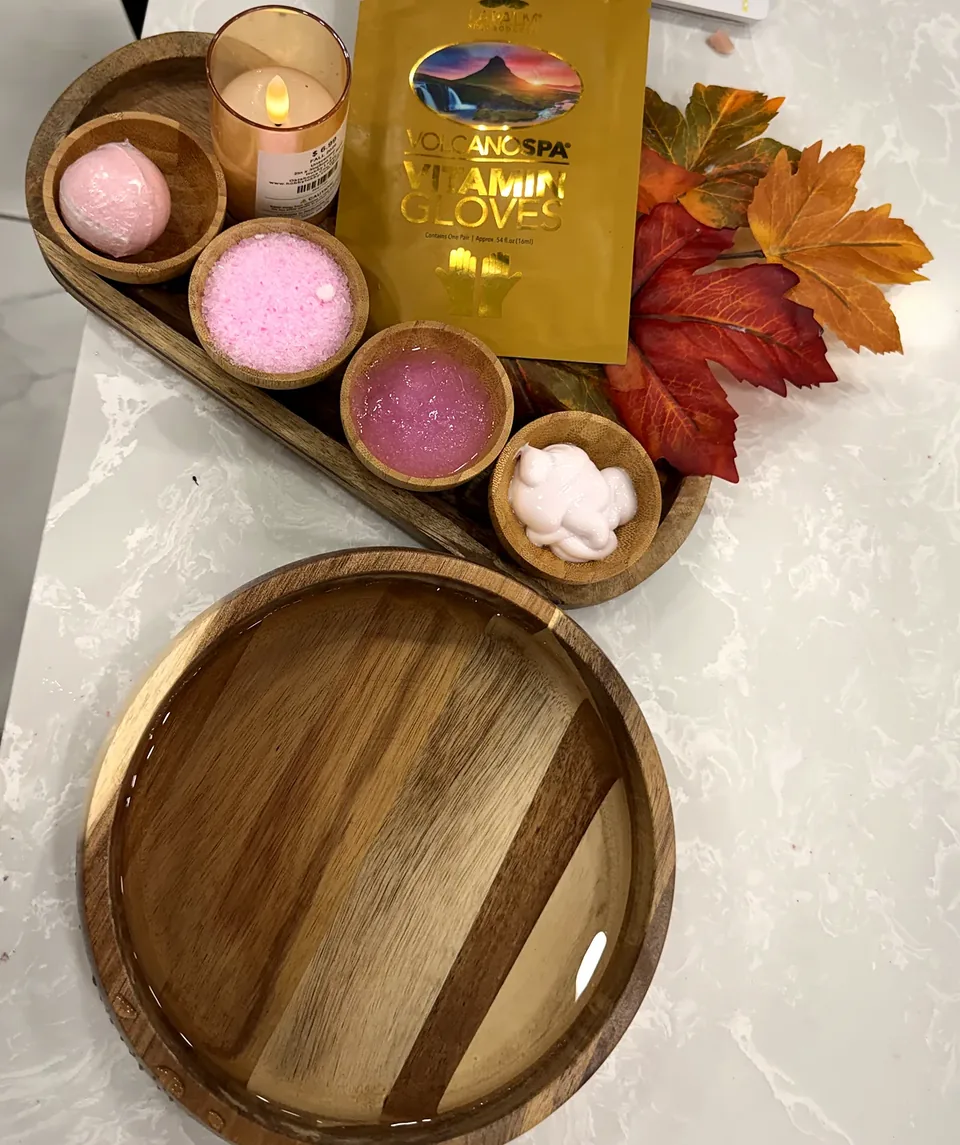 Manicure tray with Volcano Spa vitamin gloves, candle, wooden care bowls and autumn leaves