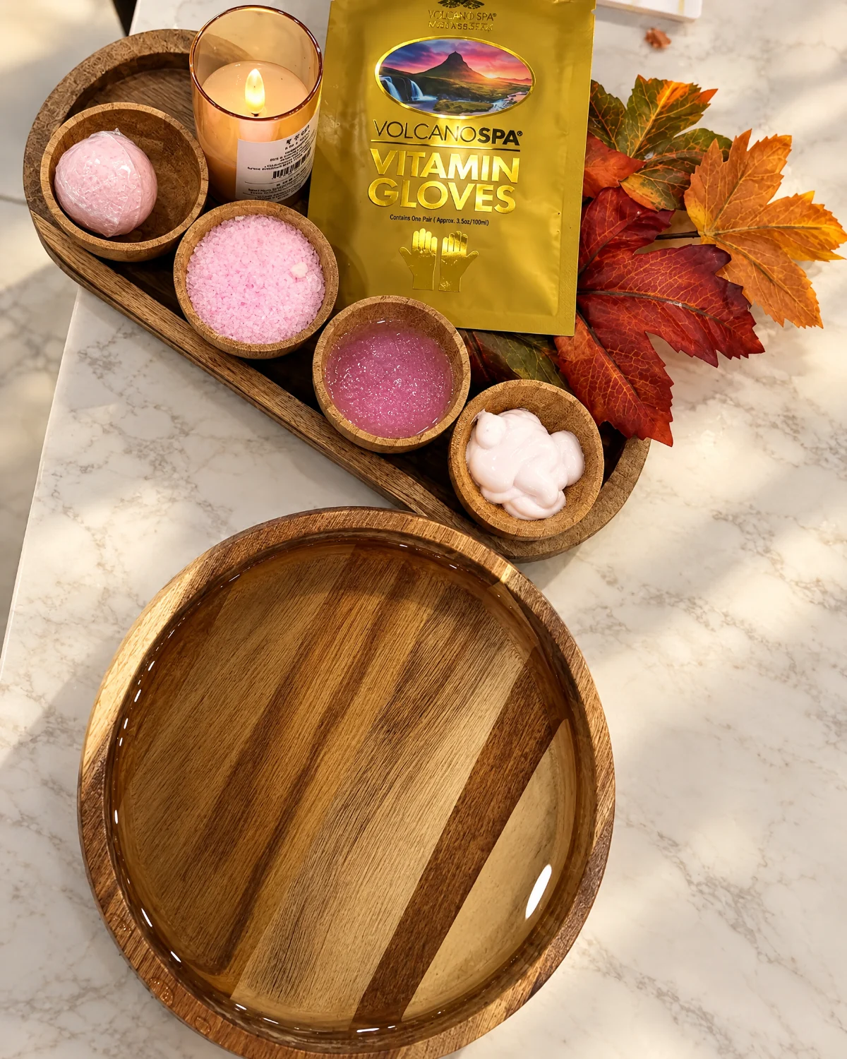 Manicure tray with Volcano Spa vitamin gloves, candle, wooden care bowls and autumn leaves