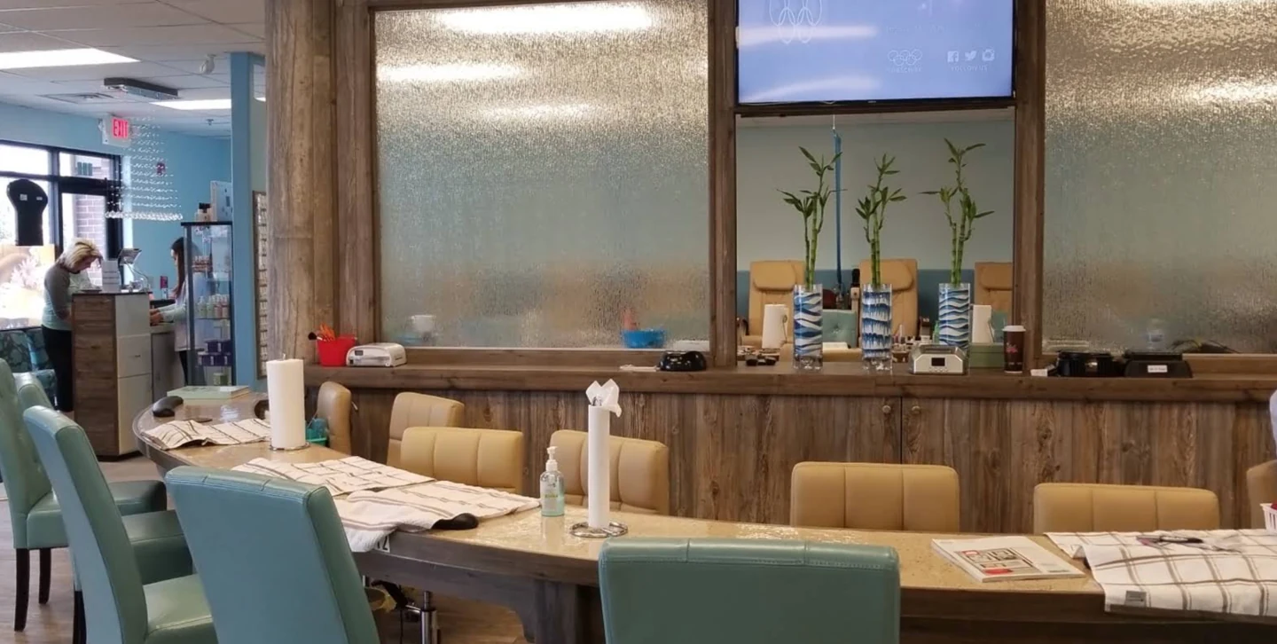 Salon interior with manicure stations, textured water wall and plants